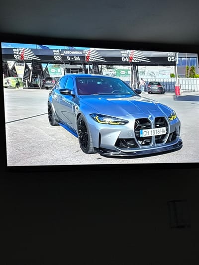The image shows a blue and silver BMW car parked at a car wash. The car's license plate reads "CB 1818 HA." The car wash has multiple bays numbered 02 through 05, and signs in Cyrillic script are visible. The precise location within the city of Hampton is not discernible from the visual information provided.