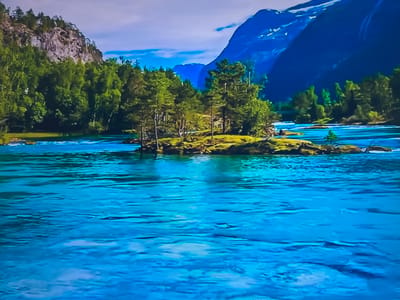 The image depicts a vibrant, natural landscape. In the foreground, a clear, turquoise river flows rapidly, exhibiting subtle ripples and currents. The water reflects the colors of the sky and surrounding environment. In the middle ground, a small, verdant island is populated with trees, with a mountain looming in the background. Other trees also are on the left side. The sky above is a mix of white and blue, with a hint of clouds. No people or animals are visible in the scene. The location is not in the city of Basingstoke and Deane, United Kingdom. This is a landscape image of a river in a forested area, likely somewhere in the mountains of Scandinavia.