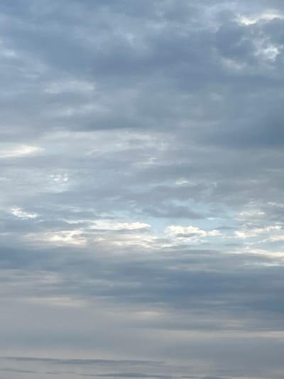The image displays a cloudy sky. The clouds appear to be layered, with some areas appearing brighter and more illuminated than others. The overall color palette is predominantly gray and white, suggesting overcast conditions. The scene is entirely composed of the sky, with no terrestrial elements visible. There are no people, subjects, or specific objects depicted in the image. The environment is solely the sky. The location in the city of Appany, Russia, is not evident from the visual information provided in the image.