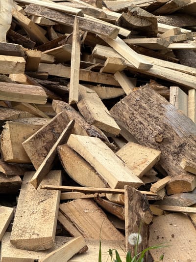 The image shows a pile of scrap wood pieces of various sizes and shapes. The wood appears to be unfinished and unpainted, with varying textures and colors. Some pieces have bark still attached. The context of Medvedka, Russia, is not apparent from the image itself.