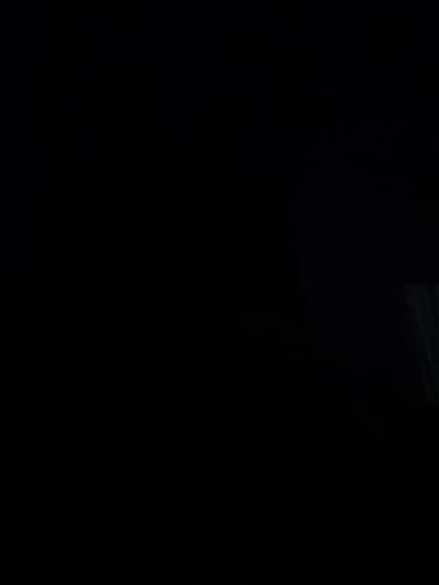 The image depicts a dark, abstract scene with faint, blurry hints of what might be greenery or foliage on the right side. The overall impression is one of low light conditions, possibly indicating nighttime or an underexposed photograph. There are no discernible people, objects, or specific landmarks that would allow for identification of a precise location within the city of Kran, Bulgaria, or any other urban setting.
