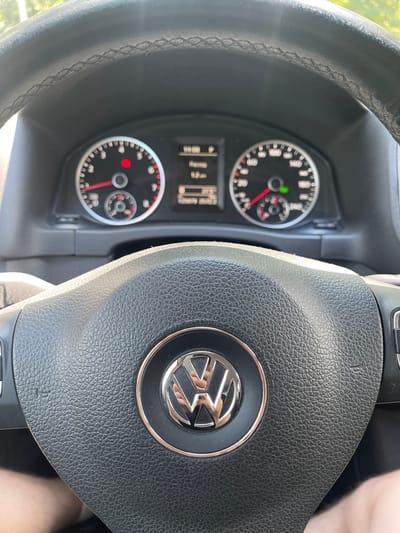 In Ivankovychi, Ukraine, the image shows the interior of a Volkswagen vehicle. The dashboard features a speedometer, tachometer, and a digital display. The steering wheel, adorned with the Volkswagen logo, is in the foreground. The ambient lighting suggests it is daytime, with sunlight filtering into the car.