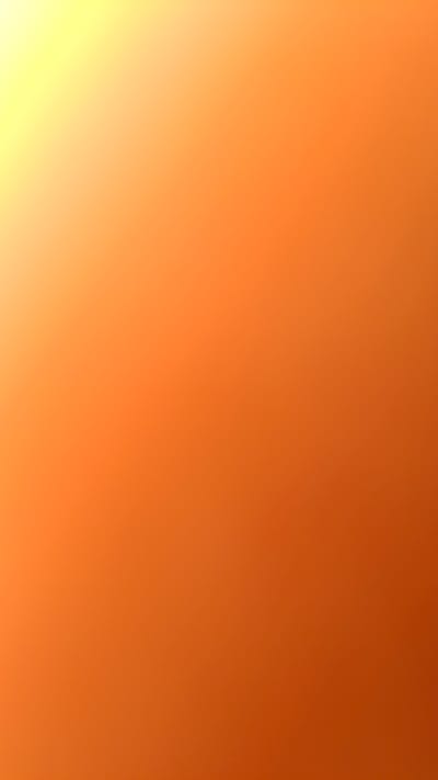 The image is a blurry gradient of orange and yellow. The color fades from a bright yellow in the bottom left corner to a darker orange in the upper right corner. There are no discernible subjects, objects, people, actions, interactions, or environmental details visible. The location of Shali, Russia is not relevant to the content of the image.