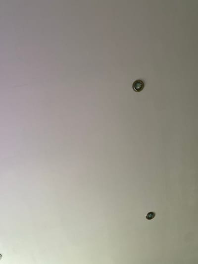 The image shows a white ceiling with three recessed lights. Two of the lights are visible and appear to be working, casting a bluish light. One light is located in the upper right portion of the image, and another is in the lower right. A third light is partially visible in the lower left corner. The ceiling is textured and appears to be made of plaster. There are no people or other objects visible in the image. The location is described as Shiryaevo, Russia, but no specific context for the image is provided.