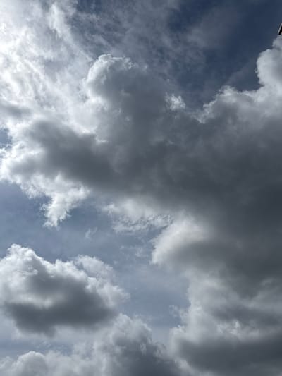 The image is an upward-facing, eye-level shot of a cloudy sky. The clouds are predominantly gray with some white areas, suggesting a mix of storm clouds and lighter, more dispersed clouds. The sky is dark blue in some parts, indicating it is likely daytime but overcast. There are no people, subjects, or objects visible in the scene other than the clouds and the sky. The environment is purely atmospheric. The image does not contain any elements that can be used to identify a specific location within the city of Barvikha, Russia.