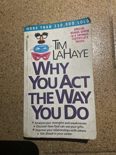 A book titled "Why You Act the Way You Do" by Tim LaHaye is lying on a speckled, beige tiled floor. The book's cover is primarily white with prominent purple text for the title. At the top of the cover, a blue band contains the text "MORE THAN 250,000 SOLD." To the right of this text, in pink, is "SPECIAL BONUS OFFER $10 SAVINGS CERTIFICATE INSIDE." The book also features graphics of two masks and a comedic disguise with glasses and a mustache. The bottom of the cover lists four bullet points, each marked with a star, detailing the book's content: "Analyze your strengths and weaknesses," "Discover how God can use your gifts," "Improve your relationships with others," and "Get ahead in your career." The book is positioned at an angle on the floor, with the bottom right corner slightly lifted. There is no indication of the city of Edopa, Nigeria, in the image.