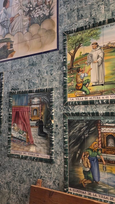This image depicts tile panels on a wall in Altura, Spain. The panels illustrate religious scenes, likely depicting miracles or significant events in the history of the city. The tiles are decorated with a marbled blue and white pattern. The panels have dark green borders with decorative detailing.

The panels show the following scenes, with text:
1. "ENTREGA DE FRAY BONIFACIO AL PAST". A monk is shown presenting a shepherd to a group of people.
2. "LA VILLA DE ALTURA A SU VIP". A man is kneeling and receiving something.
3. "CURACIÓN DEL LEPROSO MONSER". A woman is tending to a sick or injured man.
4. "A EXPENSAS DE LA VILLA DE". Text is cut off
5. "PASTOR RESUCITADO" "A EXPENSAS DEL PUEBLO DE TERESA" A man in a suit is standing beside a bed in which another man is laying.