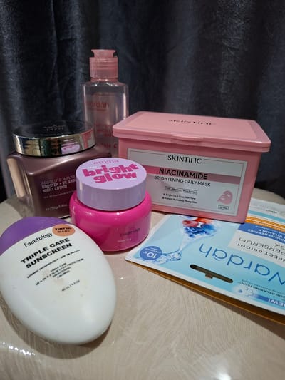The image shows a collection of skincare products. The products include a box of Skintific Niacinamide Brightening Daily Masks (30 pcs), Wardah Perfect Bright Serum, Wardah Perfect Bright Micellar Water, Tazzi Absolute Infuse Booster Night Lotion, Emmina Bright Glow Water Gel, and Facetology Triple Care Sunscreen. The image does not include information that can be used to determine the location in the city of Pie, Indonesia.