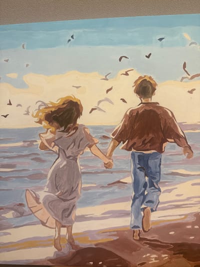 This is a painting of two people, a male and a female, holding hands and appearing to be in motion. The painting is oriented vertically, with the subjects appearing to move from bottom to top. The male figure, on the upper left, is wearing a brown jacket and blue jeans. He is facing away from the viewer and has his right arm extended upwards. The female figure, below him, is wearing a light purple dress. She is also facing away from the viewer, with her head tilted down and her hair flowing around her. Her left arm is extended upwards, holding the male's hand.
The background is abstract, with vertical lines of various colors, including blues, purples, creams, and browns, suggesting a wooded area or a similar natural setting. There are also scattered dark shapes that resemble leaves or birds in flight, particularly around the figures and in the upper left portion of the painting. The overall impression is one of movement, possibly dancing or running, with a sense of freedom or exhilaration. The lighting is soft, suggesting it could be late afternoon or early morning. There are no visible text elements in the painting.