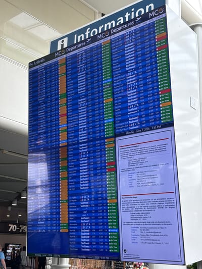 The image displays a large, vertically oriented digital flight information display board within an airport terminal. The board is divided into "MCO Information" at the top, followed by "Departures" and "Arrivals" sections. The primary activity is the presentation of real-time flight data.
The flight information is organized into columns: City, Airline, Flight number, Time, Gate, and Status. Numerous flights are listed for various airlines, including Delta, Southwest, Volaris, Air Canada, Flotam, and American, traveling to a wide range of domestic and international cities such as New York, Atlanta, Chicago, Los Angeles, Orlando, Miami, Dallas, Houston, Philadelphia, Salt Lake City, San Antonio, Seattle, Tulsa, Washington, Toronto, Montreal, Cancun, Mexico City, London, and Bogota. The majority of flights are marked "On Time," though some statuses like "Delayed," "Boarding," "Closed," "Now at Gate," and "In Range" are also visible.
A prominent feature is a legal information panel on the right side, titled "Unlawful Discrimination" in English and "Discriminación Ilegal" in Spanish. This section provides details regarding regulations against discrimination and contact information for the Federal Aviation Administration and airport ADA coordinators (Kelli White and Tawana Allen) located in Orlando, FL 32827.
The display board shows the date and time as "Monday June 1, 2026 3:35 PM" in the top and bottom right corners. The bright, indoor lighting of the airport terminal reflects slightly on the screen. In the lower right corner of the overall image, parts of what appear to be people are visible, along with gate numbers "70-79," indicating the board's placement in a passenger area.