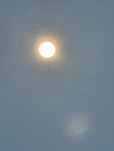A grainy, low-contrast photograph shows two luminous orbs against a mottled gray background, suggestive of a cloudy or foggy atmosphere. The orb on the left is brighter and more distinct, exhibiting a yellow-white hue, while the orb on the right is fainter and less defined, with a green tint. The scene lacks details that would establish a specific location in Zhuoshui, China. There are no discernible people, subjects, objects, actions, or interactions beyond the two light sources and the surrounding environment.