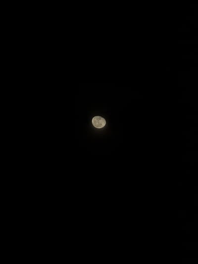 The image displays a gibbous Moon against a deep black night sky, observed from Kereka, Bulgaria. The Moon, illuminated primarily on its right side, exhibits discernible surface features, including variations in albedo and potential crater formations. It is positioned slightly above the vertical center and slightly to the left of the horizontal center in the frame. The surrounding environment is devoid of stars, clouds, or any other celestial or terrestrial objects. No people, actions, or interactions are present in the scene.