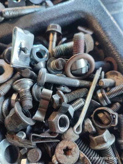 The image displays a close-up, overhead view of a container filled with various metal hardware, including bolts, nuts, washers, and clips. The objects are predominantly silver and metallic in color, with some exhibiting signs of rust or wear. The items are densely packed and appear to be a collection of assorted fasteners. The scene is indoors, as suggested by the lighting and the consistent focus on the hardware. The timestamp "17.07.2026 09:43" is visible in the lower right corner of the image. No specific location in Weitnau, Germany, can be determined from the provided image.