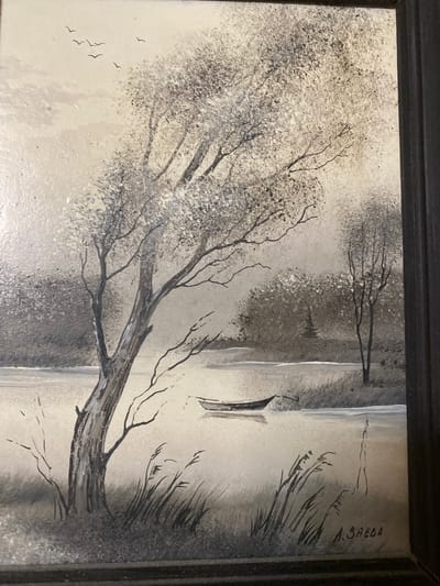 This is a painting, likely oil on canvas, framed in black. The painting depicts a somber winter landscape in grayscale. In the foreground, a large, bare tree with intricate branches dominates the left side of the frame. Its trunk is thick and gnarled, showing textured bark. To the left of the tree, a small flock of birds is flying. The middle ground features a body of water, possibly a lake or river, with a small, dark boat docked near the shore. The far bank is lined with tall, thin reeds or grasses. In the background, more bare trees and a hazy, diffused light suggest a cloudy or foggy atmosphere. The overall mood is quiet and melancholic, evoking a sense of stillness and the harshness of winter. The time of day appears to be overcast, with no direct sunlight. The location context is Novaya Usman', Russia. The signature "A. SAEBA" is visible in the upper right portion of the painting.
