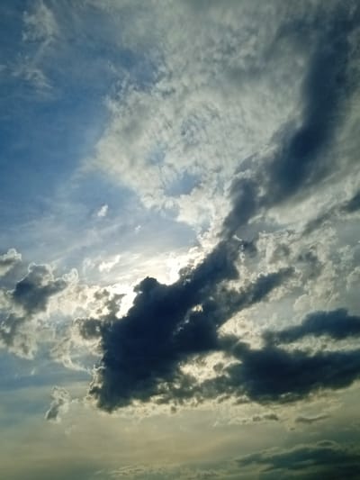 This media file captures a dramatic sky filled with a mix of dark, brooding clouds and brighter, sunlit patches. The overall scene suggests a dynamic weather condition, possibly transitioning between storms or experiencing the play of light and shadow from a setting or rising sun. The clouds are varied in texture and density, with some appearing wispy and scattered, while others are thick and heavy, casting shadows that create a sense of depth and volume.
The light is a key element, breaking through the clouds in a way that illuminates parts of the sky and highlights the edges of the darker formations. This interplay of light and shadow evokes a sense of awe and perhaps a touch of melancholy. The colors range from deep blues and grays in the shadowed areas to soft whites and yellows where the sun is more visible. The bottom portion of the image shows a more diffused, hazy light, suggesting the lower atmosphere or perhaps a distant landscape obscured by the clouds.
There are no visible people or specific objects that would indicate a particular activity or event. The focus is entirely on the natural spectacle of the sky. The location context of Taran-Bazar, Kyrgyzstan, combined with the atmospheric conditions, could suggest a rural or mountainous region where such dramatic skies are common. The time of day is likely either early morning or late afternoon due to the low angle of the sun and the quality of light. There is no visible text in the image.