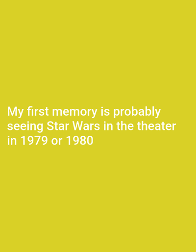 The image displays white alphanumeric text against a uniform yellow background. The text, centered horizontally in the lower third of the frame, reads: "My first memory is probably seeing Star Wars in the theater in 1979 or 1980". There are no individuals, objects, actions, or interactions depicted. The environment is solely the solid yellow color. The image provides no visual information, landmarks, or contextual cues to indicate a physical location, including the city of Lakewood, United States.