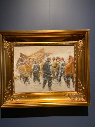 The image is of a painting in a gold frame. The painting depicts a group of men in winter clothing standing in a snowy field. There is a boat in the background. The painting is hanging on a blue wall. The coordinates provided correspond to a location in Greenwich, Connecticut. The image is of an art exhibit in the Bruce Museum. There are 15 people in the painting, all men. They are all wearing winter clothing. The men are standing in a snowy field and appear to be waiting for something. There are some houses in the background. It is snowing in the painting. The boat is in the upper left-hand corner of the painting and is half submerged in the snow. The painting is an oil on canvas, likely painted in the 19th century. The painting appears to be depicting the arrival of a boat in a snowy winter scene, with the men likely being awaiting the arrival of the boat. There is a sense of anticipation in the painting. The men are standing close together, and their bodies are turned towards the boat. The snow is falling softly and covering the ground. The painting is well-executed and the details are very realistic. The scene in the painting is peaceful and calming.
