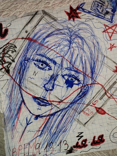 The image is a close-up, high-angle shot of a drawing on graph paper. The drawing is a rough sketch of a person's face, rendered in blue and red ink. The face is stylized with large eyes, a prominent nose, and visible lips. Blue ink is used extensively for the hair and shading, with red ink creating lines that suggest a stream or connection, and also appearing in some decorative elements like stars and what appear to be blood splatters. Text in what appears to be Russian is visible in the lower portion of the image, including "ВРЕМЯ 13.13" (Time 13.13) and "13.13 ВРЕМЯ" (13.13 Time). There are also abstract shapes, lines, and symbols scattered throughout the drawing. The background is the grid of the paper, and the top edge of the image shows a portion of a textured material, possibly fabric. There is no discernible connection to the city of Pokrovka, Russia, as the image depicts a piece of artwork and does not contain any contextual clues about its location.