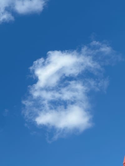 The image shows a clear blue sky with scattered white clouds. There are no people, subjects, or specific objects clearly identifiable in the image besides the clouds and the sky itself. The image does not provide any information that could be used to determine its location in Lopaskyne, Ukraine, or any other city. It is a simple photograph of the sky.