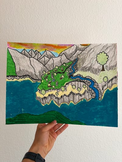 A hand holds a drawing of a landscape. The drawing depicts a mountainous region with a body of water on the right side. A river flows from the mountains down to the water. There are trees, small houses, and a circular structure on a green plain. The mountains are colored in shades of gray and white, with some areas of green and yellow. The water is a vibrant blue-green, and a strip of darker green runs along the right edge of the drawing, possibly representing a forest or more vegetation. The left side of the drawing features a colorful gradient of red, orange, yellow, blue, and pink, perhaps representing a sunset or a rainbow against the mountains. The drawing is rendered in a mixed media style, appearing to use colored pencils and possibly paint. The background of the image is a textured white wall, suggesting the drawing is being presented or displayed. No text is visible in the drawing or the surrounding image. The time of day, weather, specific emotions, or the exact location within Nienburg/Weser, Germany cannot be determined from the provided image.