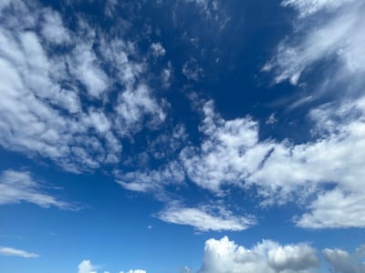 The image shows a sky filled with white clouds against a deep blue background. The clouds vary in size and shape, with some appearing as small, scattered puffs and others as larger, more defined formations. In the lower part of the image, a cluster of denser, more voluminous clouds is visible. The clear blue sky is visible between the clouds. The image does not provide information to determine a location. There is no information to verify this image was taken in Roßdorf, Germany. There are no people, subjects, objects, actions, or interactions in the image.