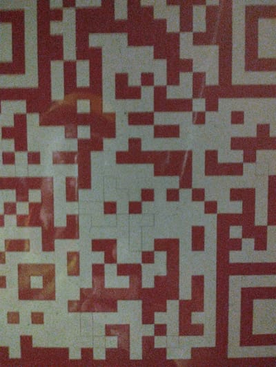 The image displays a close-up, somewhat grainy, textured pattern of red and off-white squares, resembling a QR code or a mosaic. The pattern is abstract and lacks any discernible human figures, specific objects, or identifiable environmental features. It is impossible to determine the location within Bastida Pancarana, Italy, or any contextual information from the provided image alone. The image is purely a visual representation of a geometric design.