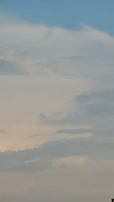 The image shows a cloudy sky. The clouds are a mix of white and gray, with some areas of light pink and yellow suggesting the presence of the sun below the horizon, possibly indicating sunrise or sunset. The sky is vast and open. No specific landmarks or buildings of Roßleben, Germany are visible.