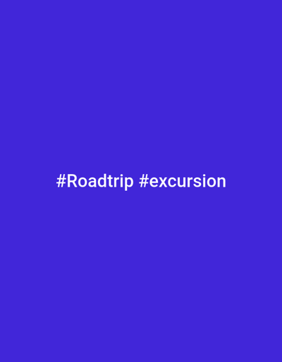 The image displays a uniform, solid blue background. Centered horizontally in the lower portion of the frame are two white hashtags: "#Roadtrip" followed by "#excursion". No other discernible features, individuals, objects, actions, interactions, or environmental details are present. The image does not contain any visual information to determine a specific geographical location, including the city of Makera, Nigeria.