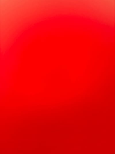 This is a full-frame, evenly lit, abstract photograph of a solid red surface. There are no discernable objects, people, or environmental details present in the image. The color is a vibrant, uniform red with a subtle gradient effect, lighter at the top and slightly darker towards the bottom, suggesting a smooth, possibly glossy, material. The location of Artik, Armenia is not discernible from the image.