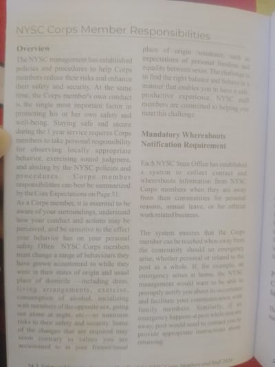 The image shows a page from a printed document, likely a handbook or manual. The text is predominantly in English, with a title "NYSC Corps Member Responsibilities" and subsequent sections labeled "Overview" and "Mandatory Whereabouts Notification Requirement." The text discusses policies, safety, conduct, and communication for NYSC corps members. There are no visible elements that would suggest a location in Magajin Gari, Nigeria, or any specific city. The image is a close-up of the printed page, with no environmental context visible.