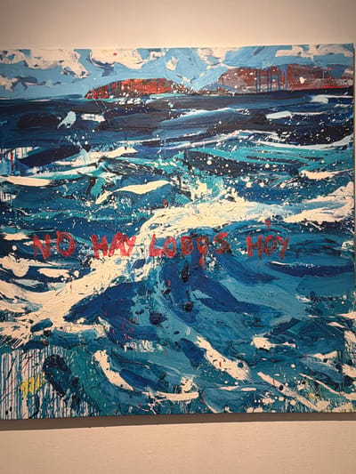 This is a medium shot of an abstract painting displayed on a plain wall. The painting is predominantly in shades of blue, white, and black, with some streaks of red and a small area of yellow. It features thick, impasto brushstrokes creating a textured, dynamic surface. Splatters and drips of paint are evident throughout, adding to the energetic feel. Vertical elements, formed by brushstrokes, dominate the composition, interspersed with broader swaths of color.
On the right side of the painting, in red lettering, the word "NOTION" is written vertically. The letters are stylized and appear to be painted with the same textured technique as the rest of the artwork.
The painting is illuminated by light from the right, casting a subtle shadow on the left edge of the canvas and highlighting the texture of the paint. The background is a plain, light-colored wall, suggesting it is displayed indoors, possibly in a gallery or home setting in San Cristóbal De La Laguna, Spain. No people or specific objects are depicted beyond the painting itself. The overall impression is one of intense movement and raw expression, perhaps evoking elements of nature like water or wind.