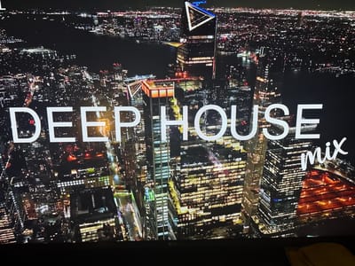 This is a nighttime aerial shot of a modern city skyline with the text "DEEP HOUSE mix" superimposed on the image. The city is illuminated by countless lights from buildings and streets, creating a vibrant and energetic atmosphere. Skyscrapers with intricate architectural designs dominate the view, some featuring unique geometric shapes and illuminated facades. The lights of the city extend to the horizon, where a body of water is visible, reflecting the urban glow. The text "DEEP HOUSE mix" is displayed in large, white, sans-serif font across the center of the image, with "mix" written in a stylized, cursive font to the right. The overall impression is one of urban dynamism and a celebration of electronic music. There are no people or specific landmarks that can definitively identify the city as Małkowo, Poland, or any other specific location.