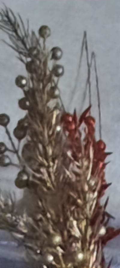 The image shows a close-up of a dried floral arrangement with small, spherical ornaments attached. The arrangement appears to be made of dried grasses or reeds, with some silvery-gray and reddish-brown elements. The ornaments are small, round, and shiny, resembling tiny beads or berries. There are also what appear to be thin, dark lines in the background, possibly strings or wires from which the arrangement is suspended, or part of the background itself. The lighting is soft, with some highlights on the ornaments. The overall impression is of a decorative item, possibly for a holiday or seasonal display. The image does not provide any information about the city of Bocani, Moldova.