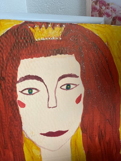 This is a close-up, horizontal, eye-level, indoor photograph of a painting. The painting itself is a portrait of a person, possibly a queen or a princess, given the presence of a crown on the left side of the image. The subject has long, auburn hair that appears to have glitter sprinkled on it. The face is rendered in pale tones, with prominent green eyes and red cheeks. The mouth is depicted with a red stroke. The background is a vibrant yellow. The painting is framed by a white border on the left side. To the left of the painting, a portion of another artwork, featuring a floral pattern of pink roses, is visible. The overall style of the painting is somewhat naive or childlike, with bold lines and colors. The lighting is even, suggesting an indoor setting with artificial light. There is no visible text in the image.