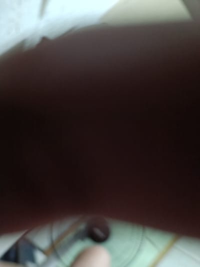 The image is extremely blurry and out of focus. It appears to be taken from a low angle, looking up at a ceiling fan, which is blurred and difficult to distinguish.  The image is too unclear to identify any people, objects, or actions, and the location provided is not relevant.