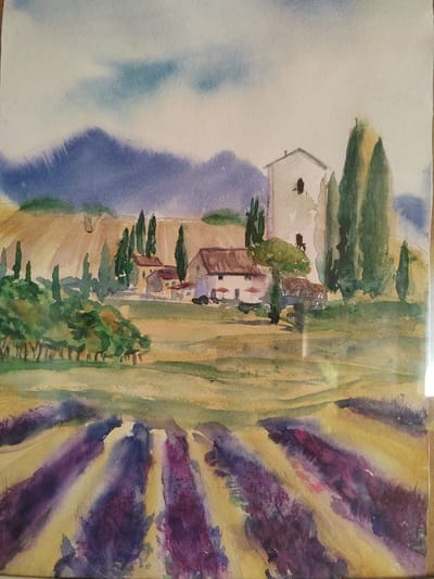This is a watercolor painting depicting a rural landscape. In the foreground, there are rows of purple and yellow plants, possibly lavender fields. In the midground, there are buildings with terracotta roofs and white walls, resembling houses or farmhouses. Tall, slender green trees, likely cypresses, are scattered around the buildings. A larger, taller structure, perhaps a tower or a tall house, is visible on the right side of the midground. The background features rolling hills in shades of brown and yellow, with a hazy blue mountain range further in the distance. The sky is light blue with some white clouds. The overall impression is a serene and picturesque countryside scene. There is no indication of any specific location within Бярэзінскі сельскі Савет, Belarus, in this artwork.