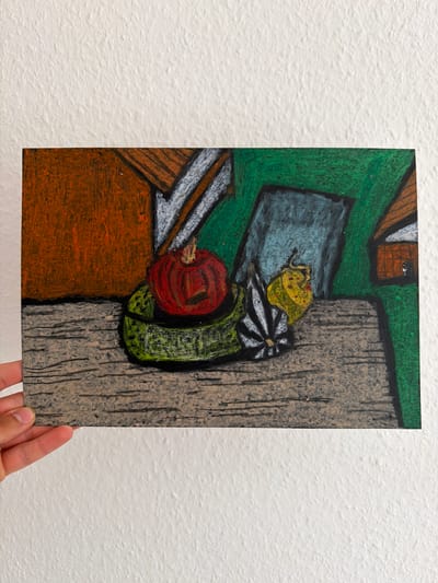 The image shows a piece of artwork held by a hand against a textured white wall. The artwork is a drawing, possibly done in pastels, depicting a still life arrangement. The scene is abstract and cubist-inspired, with bold colors and geometric shapes.

The main subjects are various objects rendered in a stylized manner. On the left side of the drawing, there's a brown rectangular shape that could represent a table or shelf. On top of this, there's a depiction of a white and gray striped object, possibly a flower or a decorative item, and a green, elongated, textured object that might be a vegetable like a zucchini or cucumber. Next to this, a bright red, circular object, possibly an apple or tomato, is visible. Above these items, a gray rectangular shape, perhaps a book or a tray, sits on a green background. Further up, there are hints of brown and white shapes suggesting rooftops or architectural elements. To the right of the central objects, a large, textured vertical shape in shades of gray and brown dominates the right side of the composition, resembling a wooden post or tree trunk with visible grain.

There are no people actively engaged in an activity within the artwork itself, only the hand holding it. The artwork does not provide cues for time of day or weather. The setting is implied by the artwork's subject matter, which is a still life, but no specific location cues are evident. The overall emotion conveyed by the artwork is abstract and perhaps playful due to the vibrant colors and simplified forms. There is no visible text in the image. The artwork is presented against a plain white, textured wall.