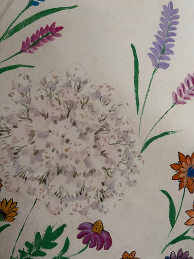 This is a watercolor painting of flowers on a textured, off-white background. The painting features several varieties of flowers, including lavender-like stalks in purple and pink, and daisy-like flowers in orange and yellow. There are also large clusters of small white and purple flowers with green stems and leaves. The style is impressionistic, with loose brushstrokes and blended colors. The painting appears to be a decorative piece, possibly wallpaper or a canvas, and does not depict any specific scene or location within the city of Кусеево, Russia.