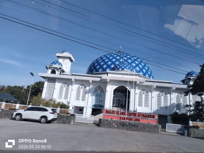 The image shows the Masjid Islamic Centre At-Taqarrub in Paya Tringgadeng, Kab. Pidie Jaya, Indonesia. The mosque has a large central dome with a blue and white checkered pattern, as well as several smaller domes and towers. The building is predominantly white with decorative archways. A white SUV is parked in front of the mosque. Power lines are visible in the sky. The image also contains a timestamp "OPPO Reno8 2026.05.23 08:32".