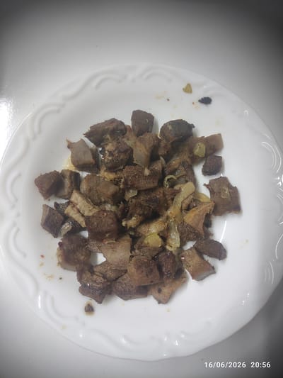 A close-up, overhead shot shows a white, circular plate with a decorative rim filled with diced, cooked meat and some onions. The meat is a dark brown color and appears to be slightly greasy, with some pieces showing a lighter, grayer interior. The onions are translucent and mixed in with the meat. The plate is on a plain, white surface. A timestamp in the bottom right corner reads "16/06/2026 20:56". The image does not provide any contextual information to determine its location in the city of Gaziosmanpaşa, Turkey.