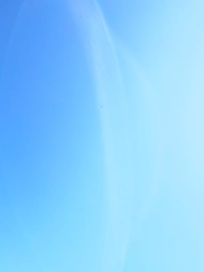 This media file is an abstract, softly lit image of a gradient of light blue and white. The light blue dominates the lower half of the frame, gradually transitioning to a lighter, almost white blue towards the top. There are faint, wispy, lighter-colored arcs or bands that suggest movement or a gentle flow within the light. A few small, darker specks are scattered across the blue expanse, which could be dust or minor imperfections in the capture. The overall impression is one of calm, serenity, and perhaps a sense of openness, like a bright, cloudless sky or diffused light. There are no discernible people, objects, or specific scene elements. The time of day and weather are not explicitly indicated, but the soft lighting suggests daytime. No text is visible. The context of Santa Marta, Colombia, does not directly inform the visual content of this abstract image.
