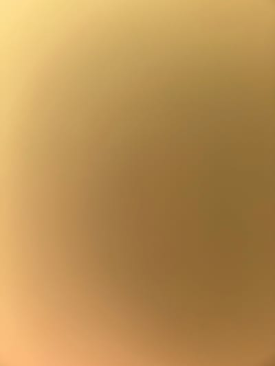 The image is a blurry, out-of-focus photograph with a gradient of light brown to light yellow. There are no discernible people, subjects, objects, actions, or interactions visible. The environment is nondescript and lacks any identifiable features to link it to the city of Zagore, Bulgaria.
