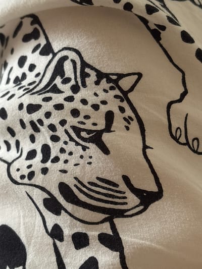 The image shows a close-up of a fabric with a black and white leopard print pattern. The print features the head and spots of a leopard. There is no indication of the city of Tikhiye Zori, Russia, in the image.