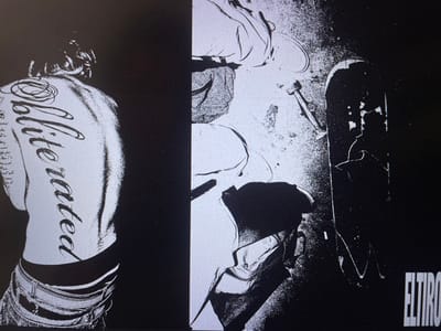 A split monochromatic image features a person from the back, with "Obliterated" tattooed vertically on their spine, wearing jeans. The right side shows a prone figure near a disassembled skateboard and truck, with scattered debris. The bottom right corner has text: "ELTIRO". The contrasting tones highlight the stark difference between the subjects in a gritty or edgy style.