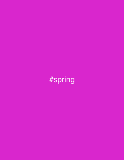 The image displays a solid magenta background. Centered horizontally in the middle of the frame is the white text "#spring". There are no people, additional subjects, objects, actions, or discernible environmental features present in the image. The image provides no visual information to indicate a specific physical location within the Municipal Unit of Ampelakia, Greece, or any other geographical area.
