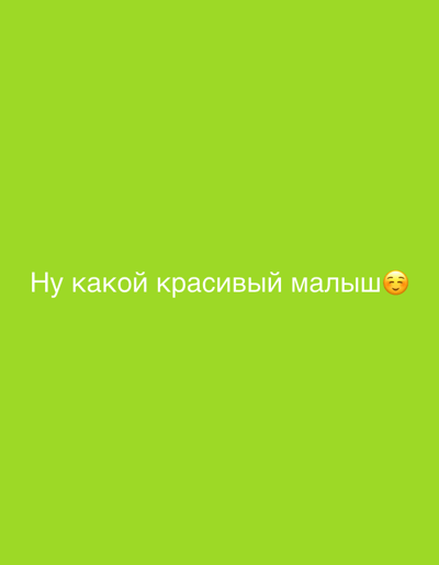 This digital image displays a solid lime-green background. Centered horizontally in the lower middle, white Cyrillic text reads "Ну какой красивый малыш" (translating to "Oh, what a beautiful baby"). Immediately following the text on the right is a yellow smiling face emoji with flushed cheeks. No other subjects, objects, or actions are depicted. The scene is a static graphic presented as being located in Селекционер-2 Снт, Russia.