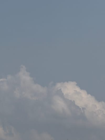 The image shows a sky with white and gray clouds. The sky is a pale blue. There are no people, subjects, objects, or actions depicted in the image. The location in the city of Solnechnyi, Russia is not identifiable from the provided image.