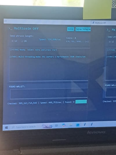 This is a close-up, low-angle, vertical shot of a laptop screen displaying cryptocurrency wallet software. The screen shows a program interface with several informational fields and controls. The main subject is the software itself, which appears to be a multi-coin wallet or checking tool.
The software displays metrics such as "Seed phrase length" with options for 12 or 24 words, and a list of supported coins including ETH, SOL, and AVAX. It also shows "Performance" at 550k checks/sec and "Speed" at 448,753/sec. A "FOUND WALLET" section indicates that 0 wallets have been found. The status is "Multicoin Off" and there's a "Setup Telegram" button. The program is actively checking wallets, with a "Checked" count of over 303 million.
The laptop itself is a Lenovo, visible in the bottom right corner where the brand name is embossed. The setting is likely indoors, given the artificial lighting and the nature of using a laptop. There are no people visible in the image. A yellow sticky note is attached to the upper left of the laptop screen. The overall impression is of a technical process being monitored on a computer. The text indicates a cryptocurrency-related operation is in progress.