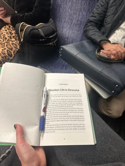 The image shows a book open to Chapter 3 titled "Shocker: Life Is Stressful." It discusses how daily stressors like notifications, slow internet, plan changes, meetings, inconsiderate people, and long lines can be overwhelming. The text emphasizes that stressing about others' behavior diminishes one's power and potential. It suggests using the "Let Them Theory" to protect oneself from unnecessary stress caused by others to conserve time and energy. A pen with "Miffy" on it lies across the pages. The page number is 55.
