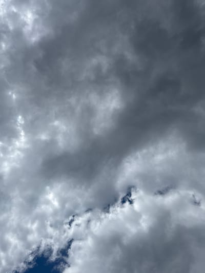 The image shows a sky filled with heavy, dark gray clouds. There are occasional patches of blue sky visible through breaks in the cloud cover. The image does not contain enough visual information to confirm it was taken in Graf Ignatievo, Bulgaria, and it does not contain people, subjects, objects, actions, or interactions. The scene is dominated by the cloudscape.